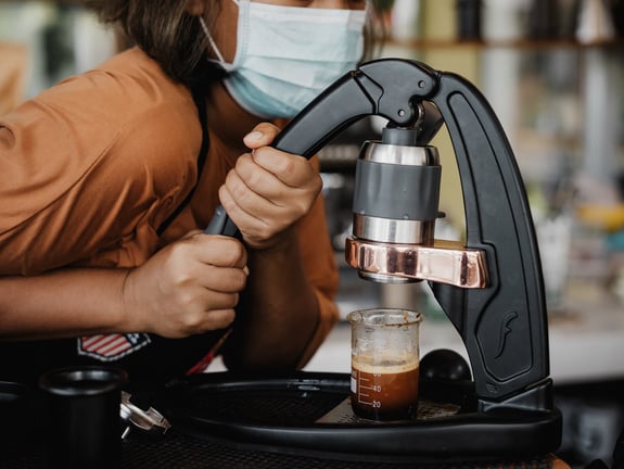 Woman in Facemask Uses Flair Espresso Maker on Table